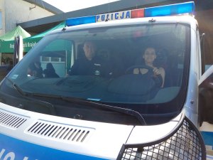 Uczestniczka w radiowozie z policjantem