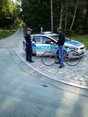 Policjant kontroluje rowerzystę