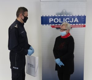 Komendant Powiatowy Policji w Sępólnie Krajeńskim wręcza książkę jednej z mieszkanek powiatu tucholskiego
