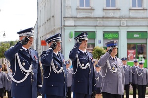 Plac Wolności w Sępólnie Krajeńskim. Uroczysta zbiórka z okazji Święta Policji. Delegacja składająca wiązankę pod pomnikiem oddaje honor.