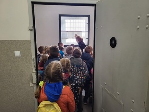 Policyjny areszt. Dzieci oglądają wnętrze celi.