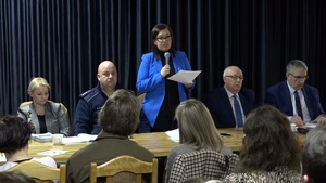Miejsko-Gminny Ośrodek Kultury w Kamieniu Krajeńskim.  Policjant siedzi przy stole razem z innymi przedstawicielami lokalnych instytucji. Przed nimi na krzesłach siedzą zgromadzeni mieszkańcy  gminy .