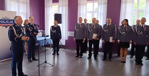 Po lewej stronie przy mikrofonie stoi Komendant Powiatowy policji w Sępólnie Krajeńskim. W oddali widać ustawionych w rzędach policjantów.