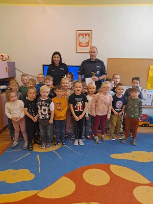 Policjanci razem z przedszkolakami pozują do wspólnego zdjęcia.