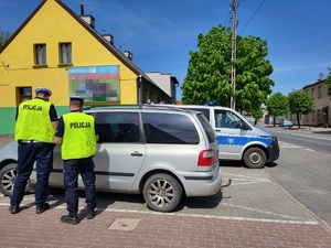 Policjanci kontrolują zatrzymany pojazd.