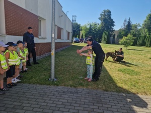 Policjantka pokazuje dzieciom jak wykonać pozycje na żółwia