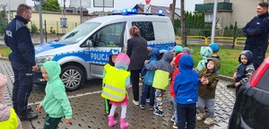 Spotkanie policjantów z przedszkolakami z sępoleńskiej &quot;trójki&quot;. Przedszkolaki oglądają radiowóz policyjny