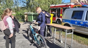 Festyn w Szkole Podstawowej w Lutowie. Policjanci znakują rowery.