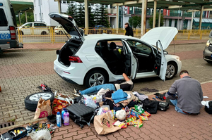 Zatrzymanie sprawców kradzieży z włamaniem. Przed pojazdem którym poruszali się sprawcy kradzieży na jezdni znajdują się zabezpieczone przez kryminalnych przedmioty ujawnione w trakcie przeszukania auta.