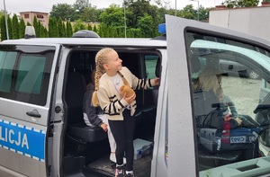 Dzieci siedzą w radiowozie