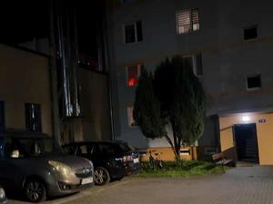 zdjęcie okna w bloku w którym widać czerwoną powłokę, płomienie ognia
