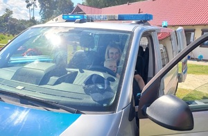 Policjantka pokazuje dziecku radiowóz policyjny