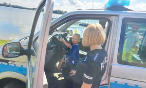 Policjantka pokazuje dziecku radiowóz policyjny