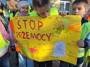 Dzieci trzymają w rękach plakat nawiązujący do tygodnia bez przemocy. Napis na plakacie : Stop Przemocy