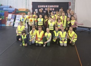 Wspólne zdjęcie dzieci ubranych w kamizelki odblaskowe oraz policjantów