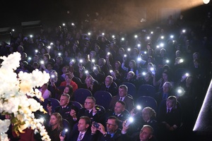 Ujęcie na siedzących na widowni uczestników koncertu. w rękach trzymają włączone latarki.
