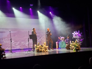 Sala kinowa w Centrum Kultury i Sztuki w Sępólnie Krajeńskim. Na scenie śpiewa policjant wraz z wokalistką , a za ich plecami na sofie siedzą dwie policjantki oraz pracownik cywilny. W tle wyświetlany jest film promujący poszczególne gminy powiatu sępoleńskiego. Po bokach sceny  ustawione są banery promujące Komendę Powiatowa Policji w Sępólnie Krajeńskim oraz Niezależny Samorządny Związek Zawodowy Policjantów w Sępólnie Krajeńskim