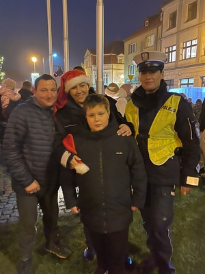 Wspólne zdjęcie policjantek z uczestnikami Mikołajek w Kamieniu Krajeńskim. Jedna z policjantek ma ubrana czapkę Mikołaja.