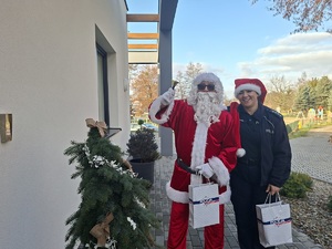 Policjantka wspólnie z Mikołajem przed budynkiem Centrum Opiekuńczo Mieszkalnego w Sępólnie Krajeńskim.