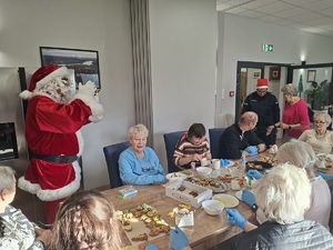 Mikołaj oraz policjantka podczas odwiedzin seniorów w Centrum Opiekuńczo Mieszkalnym w Sępólnie Krajeńskim.