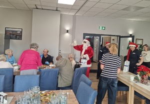 Mikołaj oraz policjantki podczas odwiedzin seniorów w Centrum Opiekuńczo Mieszkalnym w Sępólnie Krajeńskim.