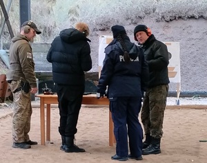 Uczestnicy konkursu stoją przy stoisku strzeleckim