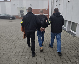 Policjanci prowadzą zatrzymanego sprawcę kradzieży