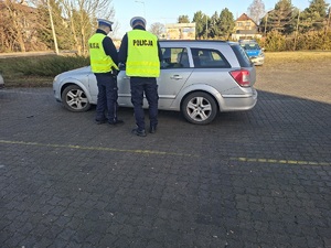 Policjanci kontrolują zatrzymany pojazd