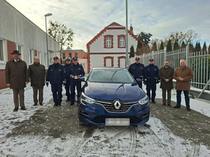 Zdjęcie grupowe na tle nowego radiowozu nieoznakowanego
