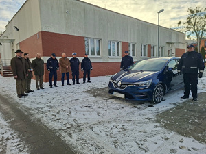 Zdjęcie grupowe na tle nowego radiowozu nieoznakowanego