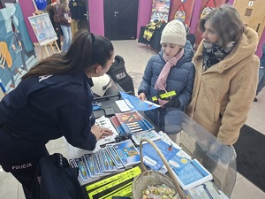 Policjantka rozmawia z dzieckiem przy stoisku profilaktyczno-promocyjnym podczas WOŚP.