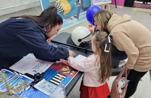 Policjantka rozmawia z dzieckiem przy stoisku profilaktyczno-promocyjnym podczas WOŚP.