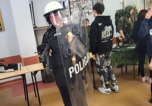 Policjanci oraz uczniowie szkół podstawowych podczas drzwi otwartych w Liceum Ogólnokształcącym w Więcborku. Jeden z uczniów ubrany jest w sprzed przeciwuderzeniowy.