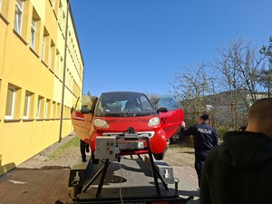 Policjant stoi przy symulatorze dachowania.