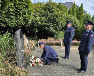 Policjanci składają symboliczną wiązankę pod pomnikiem pomordowanych policjantów.