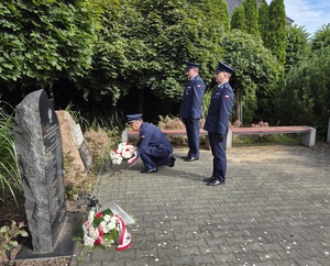 Policjanci składają symboliczną wiązankę pod pomnikiem pomordowanych policjantów.